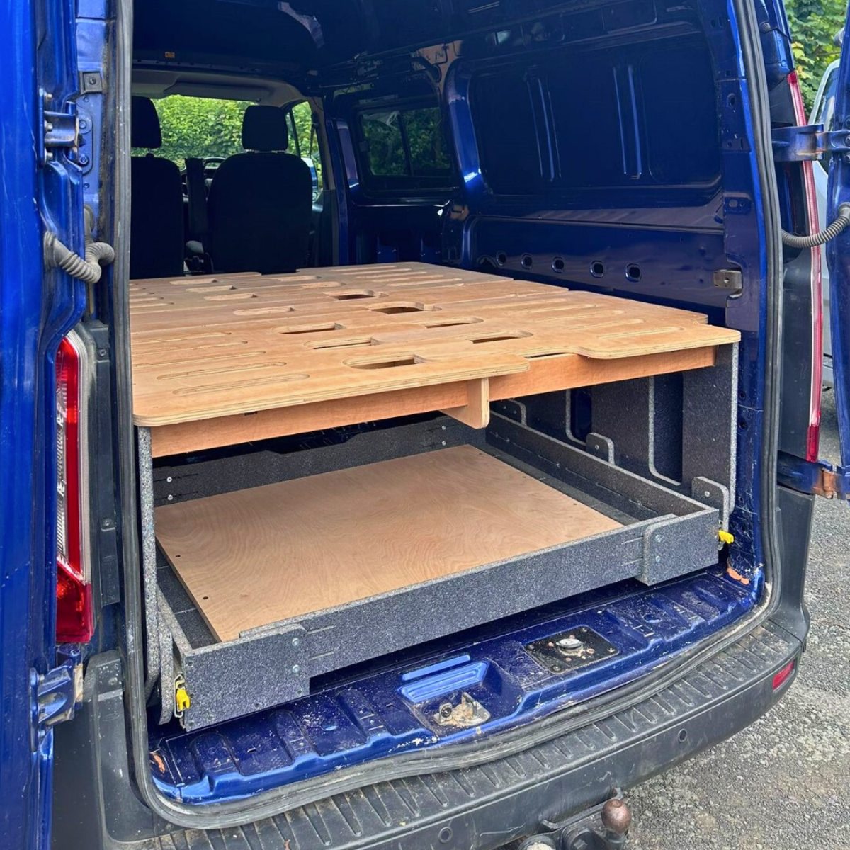 Fullwidth rear drawer stored under the camper bed in van.