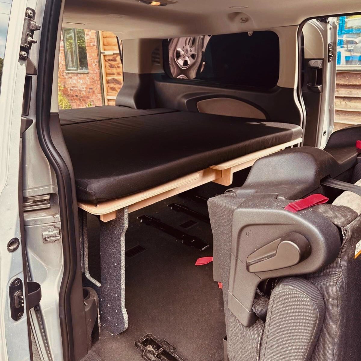 Side door view of a camper van converter kit in a Ford Torneo 2013-2021 custom.